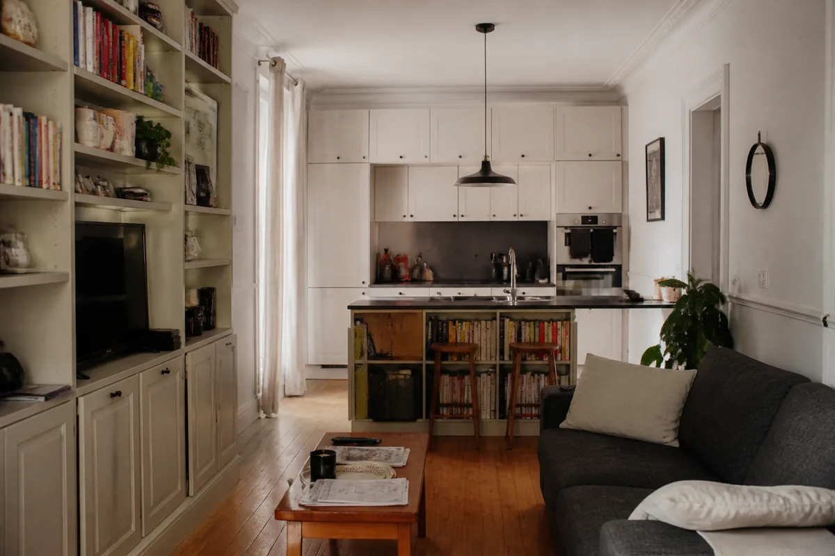 Distribución realista de una casa pequeña con cocina compacta, salón multifunción y almacenamientos integrados