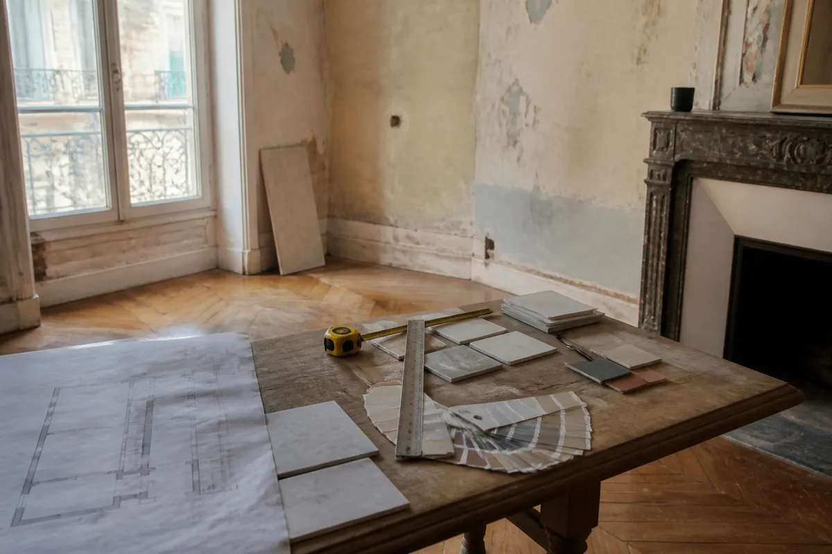 Pièce photographiée avant rénovation avec relevé de mesures et échantillons de matériaux